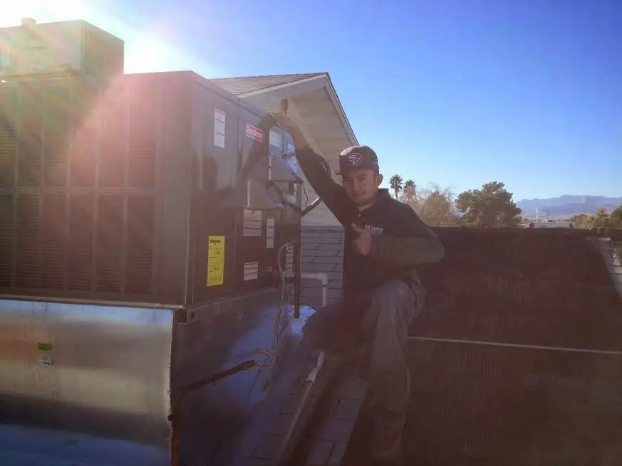 HVAC technician performing Air Duct Cleaning on a rooftop unit in Ashland